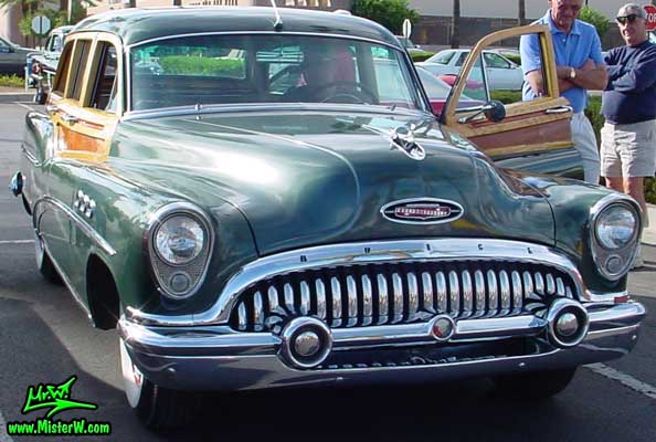 Photo of a forest green 1953 Buick Super Estate wagon, a Woodie station wagon with wood panels at the Scottsdale Pavilions Classic Car Show in Arizona. Side view of a 1953 Buick Woodie station wagon