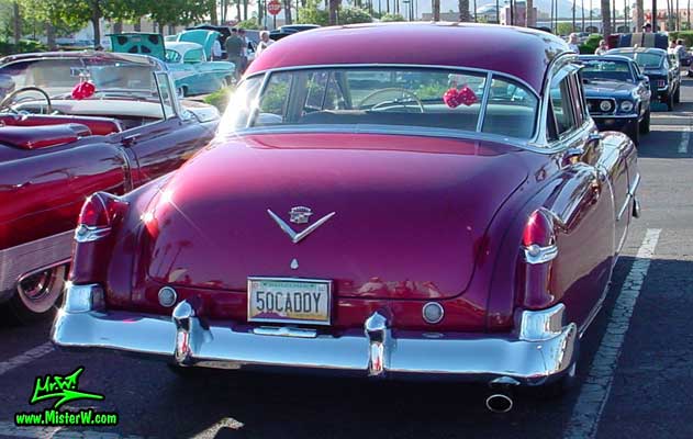 Photo of a cherry red 1950 Cadillac Series 62 4 door sedan at the Scottsdale Pavilions classic car show in Arizona. 1950 Cadillac tail fins
