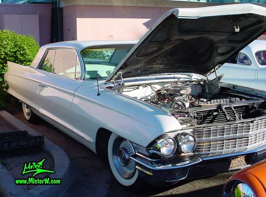Photo of a white 1962 Cadillac 2 Door Hardtop Coupe at the Scottsdale Pavilions Classic Car Show in Arizona. 1962 Cadillac engine under hood photo