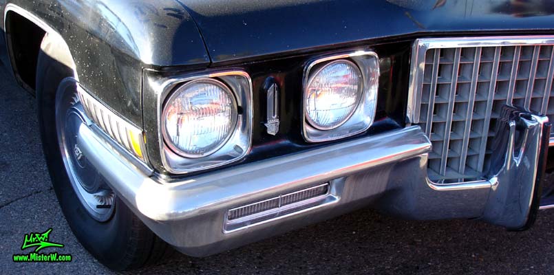 Photo of a black 1971 Cadillac Fleetwood Series 75 4 door limousine at the Scottsdale Pavilions Classic Car Show in Arizona. Headlights & blinker of a 1971 Cadillac Fleetwood Series 75 limousine
