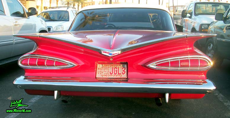 Photo of a red 1959 Chevrolet 2 Door Hardtop Coupe at the Scottsdale Pavilions Classic Car Show in Arizona. Rear view of a 1959 Chevy Coupe