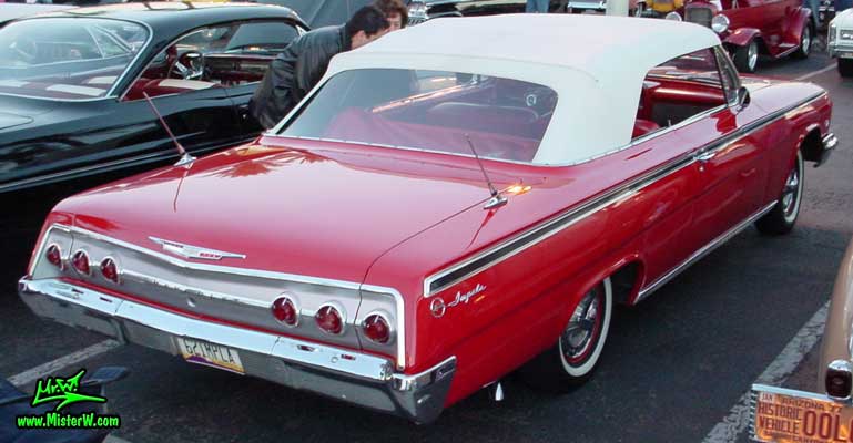 Photo of a red 1962 Chevrolet Impala Convertible at the Scottsdale Pavilions Classic Car Show in Arizona. Rearview of a 1962 Chevrolet Impala Convertible