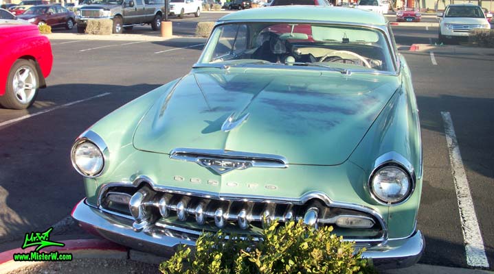 Photo of a turquoise 1955 Chrysler DeSoto Firedome 2 Door Hardtop Coupe at the Scottsdale Pavilions Classic Car Show in Arizona. Frontview of a 1955 DeSoto Firedome Coupe