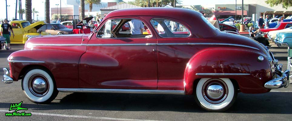 Photo of a red 1948 Dodge 5 Window Coupe at the Scottsdale Pavilions Classic Car Show in Arizona. Sideview of a 1948 Dodge 5 Window Coupe