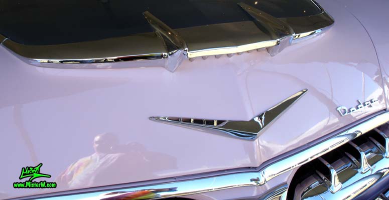 Photo of a white, pink & charcoal grey 1956 Chrysler Dodge Royal 4 Door Sedan at a Classic Car Auction in Scottsdale, Arizona. Chrome Hood Ornament of a 1956 Dodge Royal