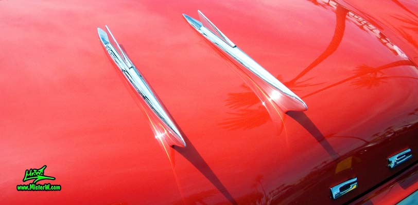 Photo of a red & white 1958 Chrysler Dodge Coronet 2 Door Hardtop Coupe at the Scottsdale Pavilions Classic Car Show in Arizona. Hood Ornaments of a 1958 Dodge Coronet Coupe