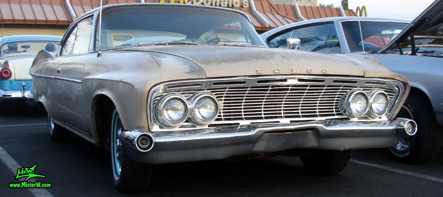 Photo of a tan 1961 Dodge 2 door hardtop coupe at the Scottsdale Pavilions Classic Car Show in Arizona. Sideview of a 1961 Dodge coupe