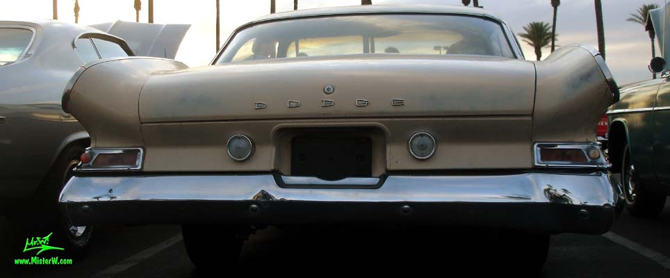 Photo of a tan 1961 Dodge 2 door hardtop coupe at the Scottsdale Pavilions Classic Car Show in Arizona. Rearview of a 1961 Dodge coupe