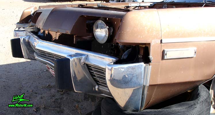 Photo of a brown 1973 Dodge Monaco 4 door hardtop sedan at a junk yard in Phoenix, Arizona. Bumper of a 1973 Dodge Monaco Hardtop Sedan