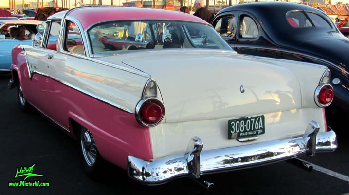 Photo of a pink & white 1955 Ford Crown Victoria 2 Door Hardtop Coupe at the Scottsdale Pavilions Classic Car Show in Arizona. Rearview of a 1955 Ford Crown Victoria Hardtop Coupe