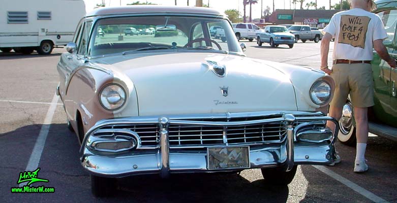 Photo of a white & pink 1956 Ford Fairlane 2 Door Post Club Sedan at a classic car meeting in Phoenix, Arizona. Frontview of a 56 Ford Fairlane Club Sedan