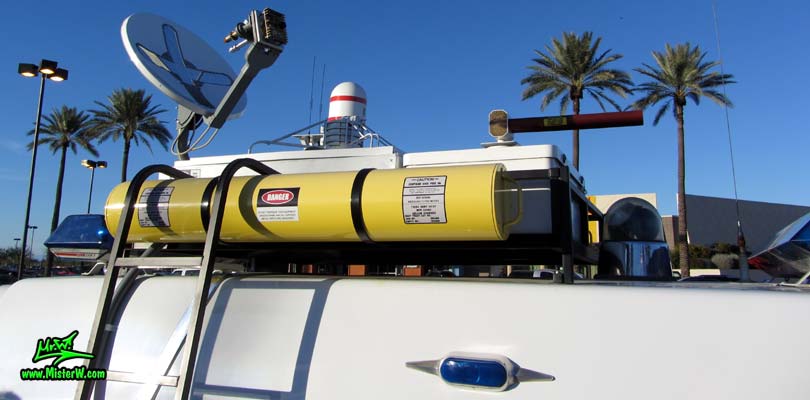 Photo of a red & white Pontiac Ambulance turned into ECTO-AZ the Arizona Ghostbusters Ectomobile at the Scottsdale Pavilions Classic Car Show in Arizona. Arizona Ghostbuster Ectomobile ECTO-AZ Roof Rack with Yellow Storage Tube, Directional Antenna, Marine Radome & T.V. Antenna