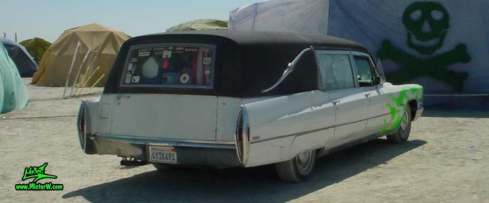 Photo of a white 1968 Cadillac Hearse at the Burning Man Festival. 68 Caddy Hearse Rearview