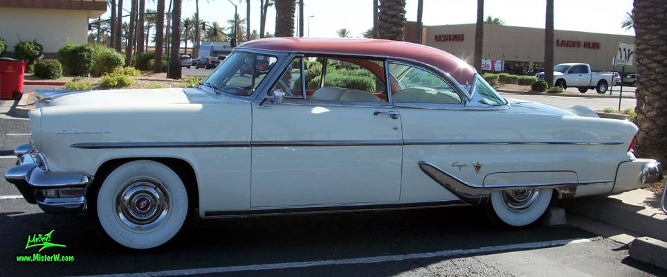Photo of a white 1955 Lincoln Capri 2 door hardtop coupe at the Scottsdale Pavilions Classic Car Show in Arizona. Side view of a 1955 Lincoln Capri hardtop coupe
