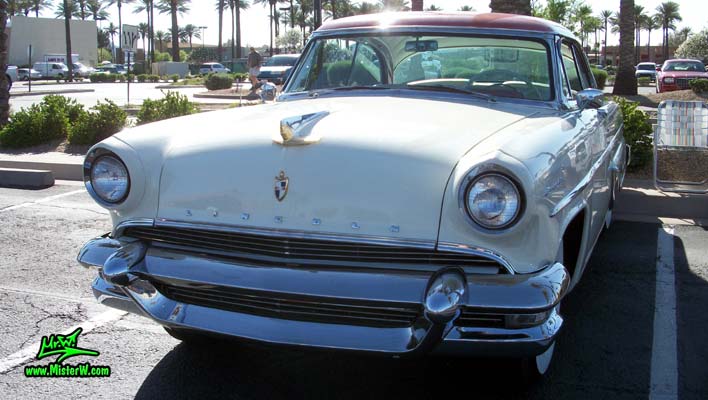 Photo of a white 1955 Lincoln Capri 2 door hardtop coupe at the Scottsdale Pavilions Classic Car Show in Arizona. Front view of a 1955 Lincoln Capri hardtop coupe