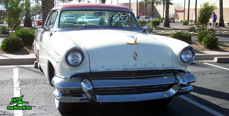 Photo of a white 1955 Lincoln Capri 2 door hardtop coupe at the Scottsdale Pavilions Classic Car Show in Arizona. Massive front chrome bumper of a 1955 Lincoln Capri hardtop coupe