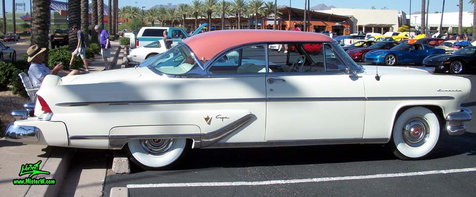 Photo of a white 1955 Lincoln Capri 2 door hardtop coupe at the Scottsdale Pavilions Classic Car Show in Arizona. Passenger's side of a 1955 Lincoln Capri hardtop coupe