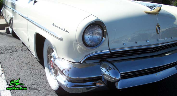 Photo of a white 1955 Lincoln Capri 2 door hardtop coupe at the Scottsdale Pavilions Classic Car Show in Arizona. Headlight & blinker of a 1955 Lincoln Capri hardtop coupe