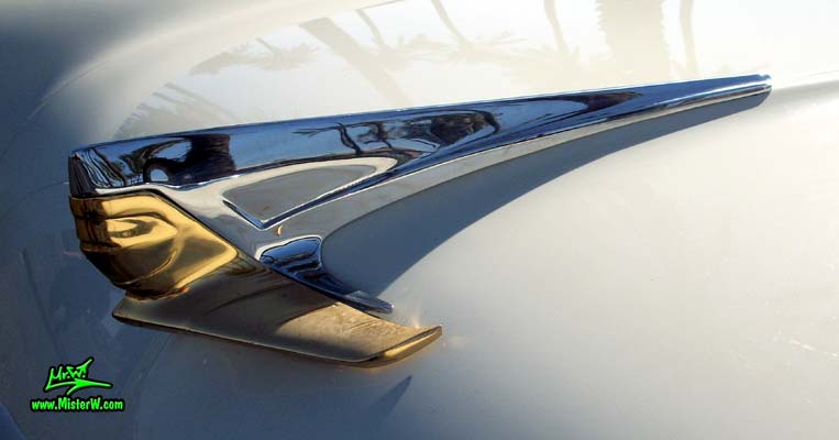 Photo of a white 1955 Lincoln Capri 2 door hardtop coupe at the Scottsdale Pavilions Classic Car Show in Arizona. Hood ornament of a 1955 Lincoln Capri hardtop coupe