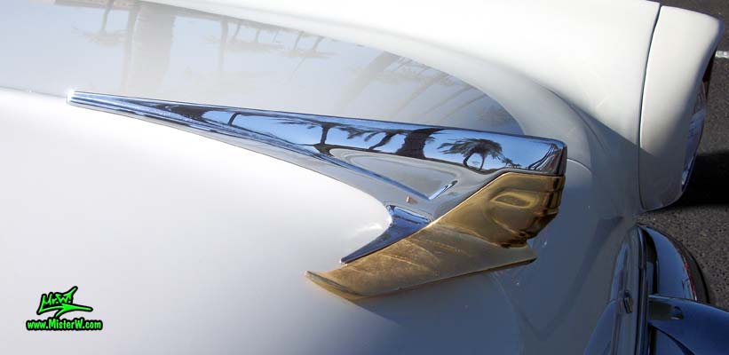 Photo of a white 1955 Lincoln Capri 2 door hardtop coupe at the Scottsdale Pavilions Classic Car Show in Arizona. Chrome hood ornament of a 1955 Lincoln Capri hardtop coupe