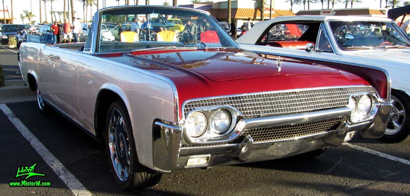 Photo of a red & white 1961 Lincoln Continental 4 door convertible at the Scottsdale Pavilions Classic Car Show in Arizona. Side view of a 1961 Lincoln Continental convertible