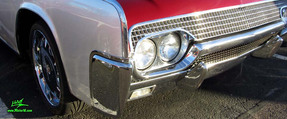 Photo of a red & white 1961 Lincoln Continental 4 door convertible at the Scottsdale Pavilions Classic Car Show in Arizona. Headlights & blinker of a 1961 Lincoln Continental convertible