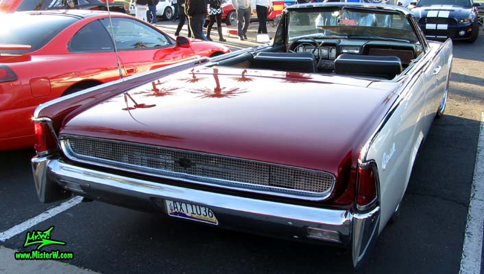 Photo of a red & white 1961 Lincoln Continental 4 door convertible at the Scottsdale Pavilions Classic Car Show in Arizona. Back of a 1961 Lincoln Continental convertible