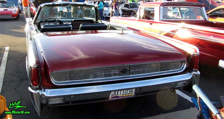 Photo of a red & white 1961 Lincoln Continental 4 door convertible at the Scottsdale Pavilions Classic Car Show in Arizona. Rear view of a 1961 Lincoln Continental convertible