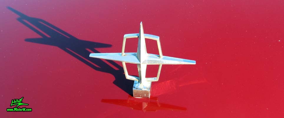 Photo of a red & white 1961 Lincoln Continental 4 door convertible at the Scottsdale Pavilions Classic Car Show in Arizona. Hood ornament of a 1961 Lincoln Continental convertible