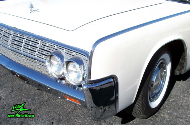 Photo of a white 1962 Lincoln Continental 4 door convertible at the Scottsdale Pavilions Classic Car Show in Arizona. Front fender of a 1962 Lincoln Continental convertible