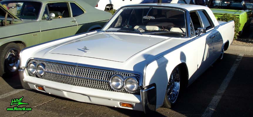 Photo of a white 1963 Lincoln Continental 4 door hardtop sedan at the Scottsdale Pavilions Classic Car Show in Arizona. Side view of a 1963 Lincoln Continental