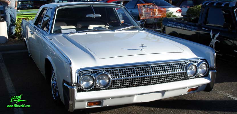 Photo of a white 1963 Lincoln Continental 4 door hardtop sedan at the Scottsdale Pavilions Classic Car Show in Arizona. Front chrome grill of a 1963 Lincoln Continental