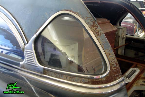 Photo of the Hearse Grave Digger a Monster Garage modified 54 Caddy with backhoe at a classic car auction in Scottsdale, Arizona. Curved window in the back of Grave Digger the Monster Garage Hearse