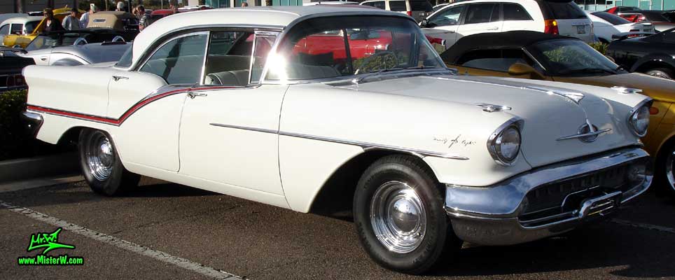 Photo of a white 1957 Oldsmobile 4 Door Hardtop Sedan at the Scottsdale Pavilions Classic Car Show in Arizona. 57 Olds Sideview