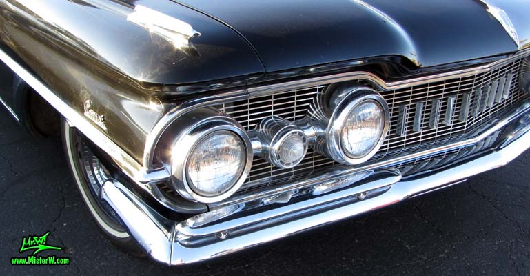 Photo of a black 1959 Oldsmobile Hearse at the Scottsdale Pavilions Classic Car Show in Arizona. Headlight of a 1959 Oldsmobile Hearse