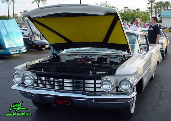 Photo of a white 1960 Oldsmobile 4 Door Hardtop Sedan at the Scottsdale Pavilions Classic Car Show in Arizona. 1960 Oldsmobile Sedan with open hood