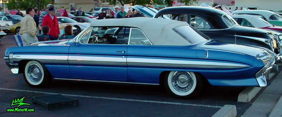 Photo of a blue metallic 1961 Oldsmobile Starfire 2 Door Convertible at the Scottsdale Pavilions Classic Car Show in Arizona. 1961 Oldsmobile Starfire Side Chrome