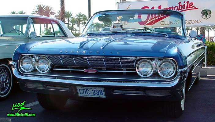 Photo of a blue metallic 1961 Oldsmobile Starfire 2 Door Convertible at the Scottsdale Pavilions Classic Car Show in Arizona. 1961 Oldsmobile Starfire Bumper & Chrome Grill