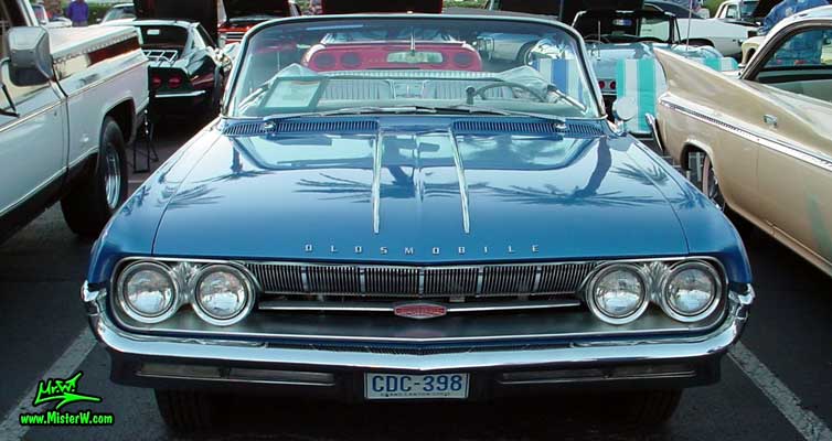 Photo of a blue metallic 1961 Oldsmobile Starfire 2 Door Convertible at the Scottsdale Pavilions Classic Car Show in Arizona. 1961 Oldsmobile Head Lights & Chrome Grill