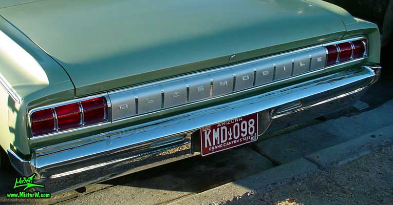 Photo of a olive 1964 Oldsmobile 2 Door Hardtop Coupe at the Scottsdale Pavilions Classic Car Show in Arizona. 64 Olds Tail Lights & Bumper