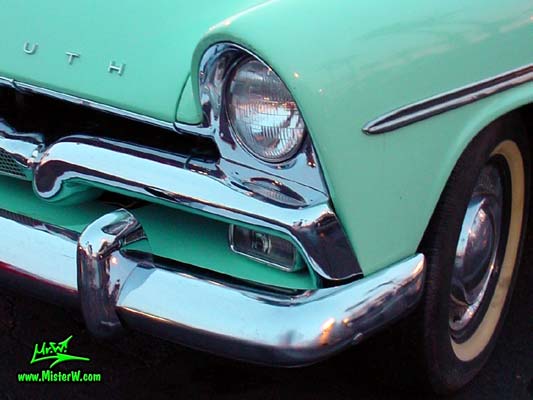 Photo of a white & turquoise 1956 Chrysler Plymouth Belvedere 4 Door Sedan at the Scottsdale Pavilions Classic Car Show in Arizona. Head Light & Crome Grill of a 56 Plymouth Belvedere
