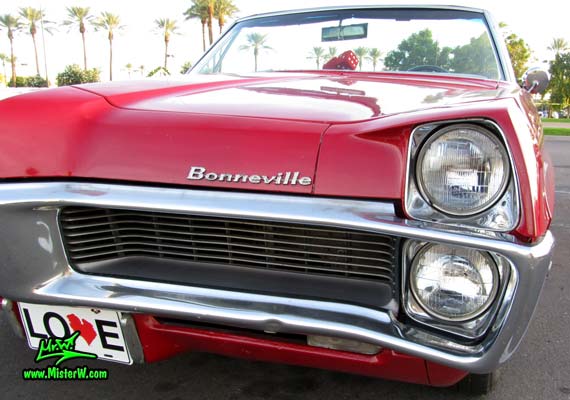 Photo of a red 1967 Pontiac Bonneville Convertible at the Scottsdale Pavilions Classic Car Show in Arizona. Head Lights of a 67 Pontiac Convertible