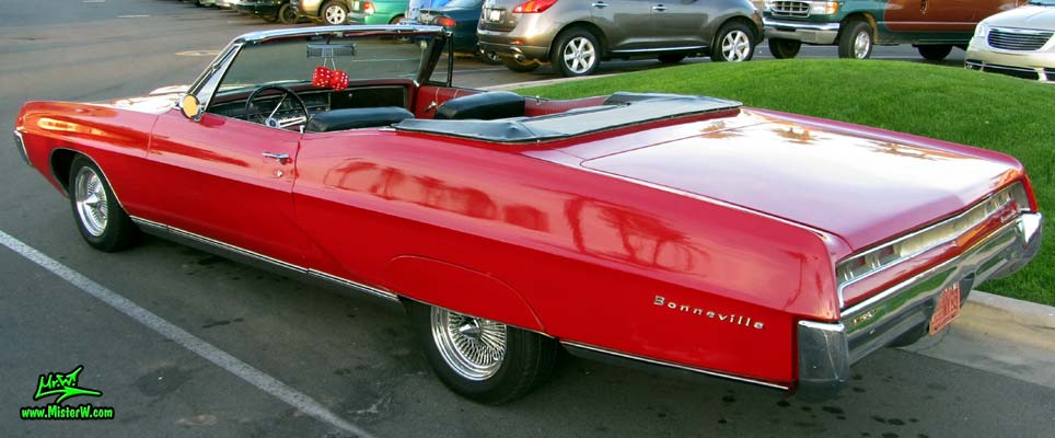 Photo of a red 1967 Pontiac Bonneville Convertible at the Scottsdale Pavilions Classic Car Show in Arizona. 1967 Pontiac Bonneville With The Top Down
