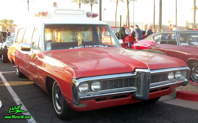 Photo of a red & white 1968 Pontiac Bonneville Ambulance at the Scottsdale Pavilions Classic Car Show in Arizona. Sideview of a 68 Pontiac Bonneville Ambulance