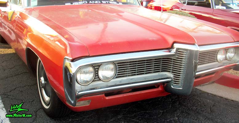 Photo of a red & white 1968 Pontiac Bonneville Ambulance at the Scottsdale Pavilions Classic Car Show in Arizona. Chrome Front Grill of a 68 Pontiac Bonneville Ambulance