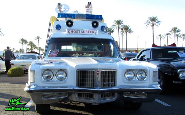 Photo of a red & white Pontiac Bonneville Ambulance at the Scottsdale Pavilions Classic Car Show in Arizona. Frontview of a 72 Pontiac Pontiac Bonneville Ambulance