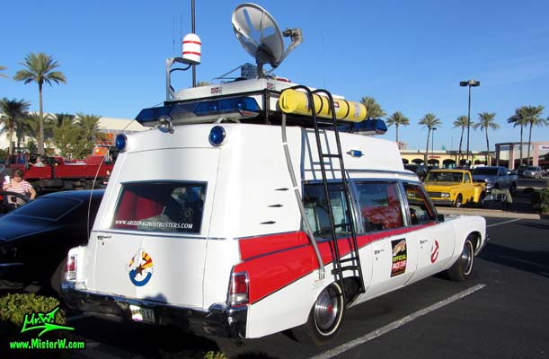 Photo of a red & white Pontiac Bonneville Ambulance at the Scottsdale Pavilions Classic Car Show in Arizona. Ecto Roof Rack with Ghostbuster Equipment of a 72 Pontiac Pontiac Bonneville Ambulance