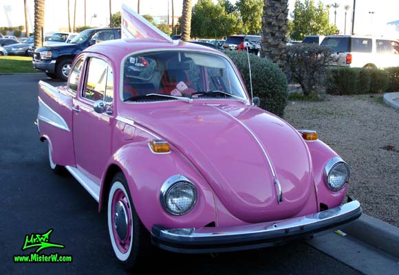 Photo of a customized pink Volkswagen Kaefer / Bug / Beetle modified with 1957 Chevrolet Fins at the Scottsdale Pavilions Classic Car Show in Arizona. Custom 57 VW Chevy Bug Frontview