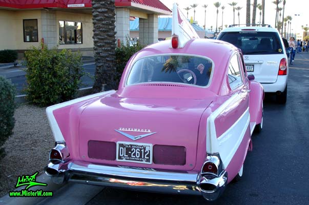 Photo of a customized pink Volkswagen Kaefer / Bug / Beetle modified with 1957 Chevrolet Fins at the Scottsdale Pavilions Classic Car Show in Arizona. The back of the VolksChevrolet a Volkswagen Kaefer morphed with a 1957 Chevrolet